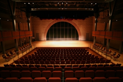 Interior view of Lee Theater stage with empty red theater seats arranged in rows.